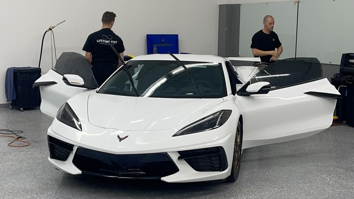 Lifetime Tint team prepping a white C8 Corvette inside the Jacksonville shop